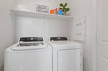 A washer and dryer in a white laundry room